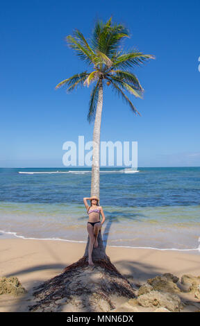 BOCAS DEL TORO, PANAMA - 20. APRIL 2018: Nicht identifizierte Frau über eine Palme posieren, in einem wunderschönen Tag mit erstaunlichen Hintergrund sunnny ladscape der Strand Insel Stockfoto