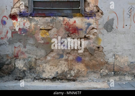 Abstract grunge Hintergrund Alte kaputte Wand, Putz, an der Spitze der Metal Fenster, rote Flecken, blauer und gelber Farbe. Stockfoto