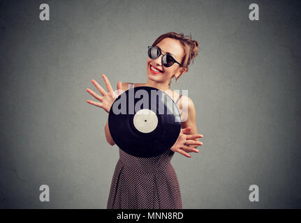 Freudige schöne junge Frau mit einem Vintage vinyl Stockfoto