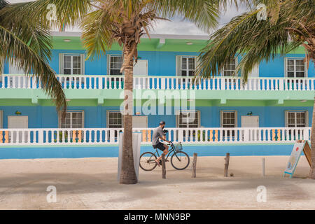 Caye Caulker, Belize - Dezember 24, 2016: Blick auf das Hotel und man Reiten Fahrrad auf der Main Street in Caye Caulker. Es ist eine kleine Insel in der Nähe von Stockfoto