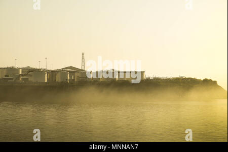 Öltanks an der Küste ausserhalb Cardiff Docks am frühen Morgen Licht mit Licht meer Nebel Stockfoto