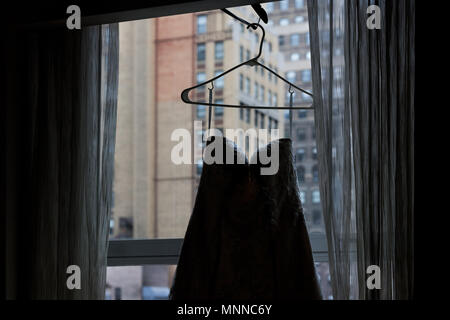 Nahaufnahme der Hochzeit Kleid hängen Aufhänger der Fenster mit Jalousien, Fensterbänke in der Stadt New York City NY NYC Hotel Hochhaus apartment Condo Gebäude Stockfoto