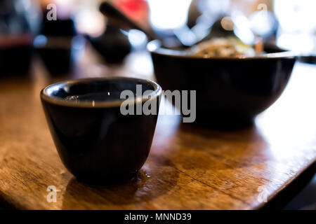 Nahaufnahme der Mahlzeit zum Mittag- oder Abendessen Gerichte in japanischen traditionellen asiatischen Restaurant oder Cafe mit ochazuke, Kaffee Tasse Teetasse auf holztisch Makro Stockfoto