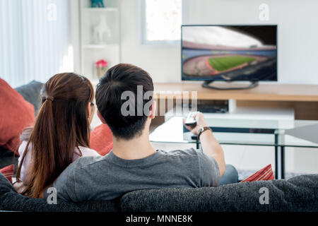 Ansicht der Rückseite des asiatischen Paar, Fußball im Fernsehen im Wohnzimmer. Fußball festival Konzept. Stockfoto