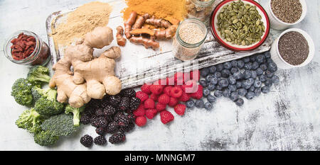 Verschiedene superfoods auf weißem Holzbrett. Gesunde Ernährung Konzept Stockfoto
