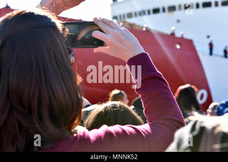 Ein Familie Mitglied nimmt ein Foto von einem Crewmitglied an Bord der Coast Guard Cutter Polar Star, wie die Mannschaft es Mauren zum Pier an der Basis Seattle, 16. März 2018. Das Seattle-based Polar Star Port im Dezember für die Antarktis links Operation Deep Freeze 2018 zu unterstützen, der Beitrag des US-Militärs in die US Antarctic Program, die von der National Science Foundation betrieben wird. Us-Küstenwache Stockfoto