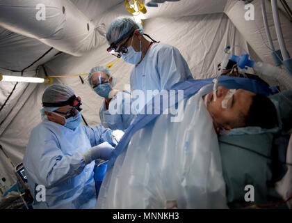 PUERTO Cortes, Honduras (16. März 2018) Kapitän Rob Ricca und Lt.Cmdr. Greg Chesnut eine Hernie Betrieb auf einer Honduranischen Patienten in der expeditionary medizinische Einheit in Puerto Cortes, Honduras durchführen, während weiterhin Versprechen 2018. Us Naval Forces Southern Command/USA 4. Flotte hat eine Kraft entfaltet Auszuführen weiterhin Versprechen zivil-militärische Operationen durchzuführen, einschließlich humanitärer Hilfe, Ausbildung Engagements und medizinische, zahnmedizinische und veterinärmedizinische Unterstützung in einer Bemühung, US-Unterstützung und Engagement in Zentral- und Südamerika zu zeigen. Stockfoto