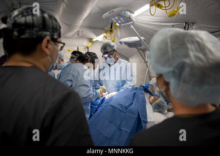 PUERTO Cortes, Honduras (16. März 2018) Kapitän Rob Ricca und Lt.Cmdr. Kathryn L. Rutan eine Hernie Betrieb auf einer Honduranischen Patienten in der expeditionary medizinische Einheit in Puerto Cortes, Honduras durchführen, während weiterhin Versprechen 2018. Us Naval Forces Southern Command/USA 4. Flotte hat eine Kraft entfaltet Auszuführen weiterhin Versprechen zivil-militärische Operationen durchzuführen, einschließlich humanitärer Hilfe, Ausbildung Engagements und medizinische, zahnmedizinische und veterinärmedizinische Unterstützung in einer Bemühung, US-Unterstützung und Engagement in Zentral- und Südamerika zu zeigen. Stockfoto