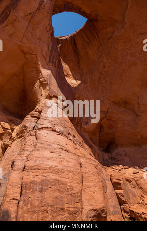 Sonnen Auge. Schlagloch Natural Arch in Sandstein erodiert. Navajo Tribal Park von Monument Valley, Arizona, Utah, USA Stockfoto