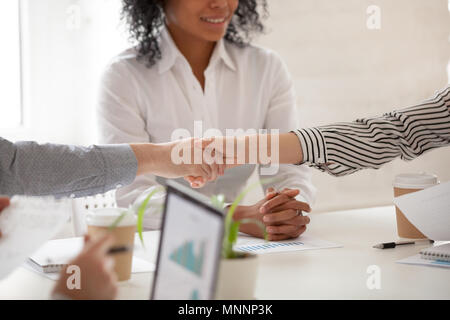 Kaufmann und Kauffrau handshaking an verschiedenen Gruppe meeti Stockfoto