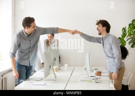 Fröhliche männlichen Kollegen Faust bumping feiert erfolgreiche Kaffee Stockfoto