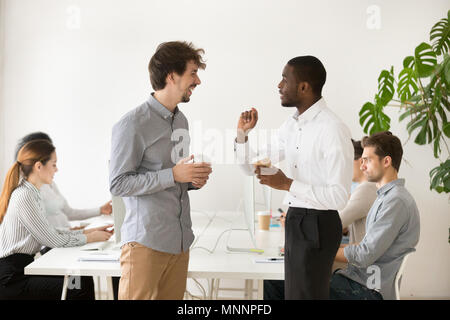 Freundlich multirassischen Kollegen zusammen Chatten in Office duri Stockfoto