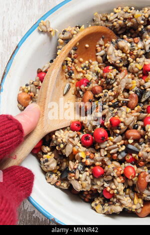 Schritt für Schritt 2/7: Winter berry Futterhäuschen mit Ausstecher. Mix Nüsse, Samen und Beeren mit geschmolzenem Fett. Gut umrühren, um sicherzustellen, dass Fett deckt alle. Stockfoto