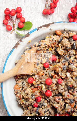 Schritt für Schritt 2/7: Winter berry Futterhäuschen mit Ausstecher. Mix Nüsse, Samen und Beeren mit geschmolzenem Fett. Gut umrühren, um sicherzustellen, dass Fett deckt alle. Stockfoto