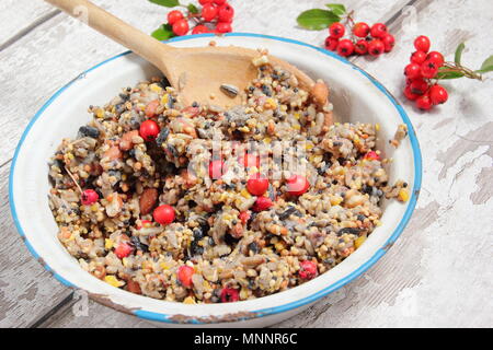 Schritt für Schritt 2/7: Winter berry Futterhäuschen mit Ausstecher. Mix Nüsse, Samen und Beeren mit geschmolzenem Fett. Gut umrühren, um sicherzustellen, dass Fett deckt alle. Stockfoto