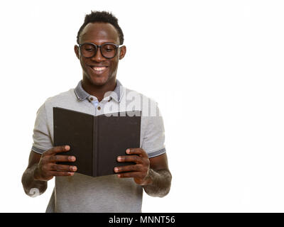 Junge glücklich afrikanischer Mann lächelnd, während Buch lesen Stockfoto