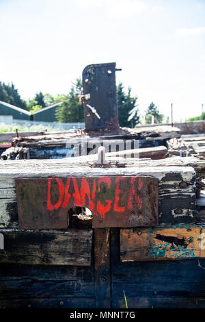 Warnschild auf verrottendem Holz- Struktur eines alten cargo Aufsch. Stockfoto
