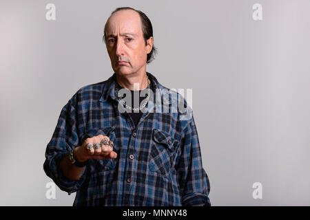 Studio shot reifer Gangster Mann seine Ringe angezeigt Stockfoto