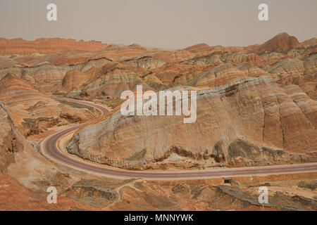 Kurvenreiche Straße durch die malerische Zhangye Danxia Relief geologischen Park, Gansu, China Stockfoto