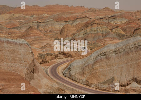 Tour Bus durch die malerische Zhangye Danxia Relief geologischen Park, Gansu, China fahren Stockfoto