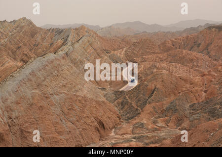 Tour Bus durch die malerische Zhangye Danxia Relief geologischen Park, Gansu, China fahren Stockfoto