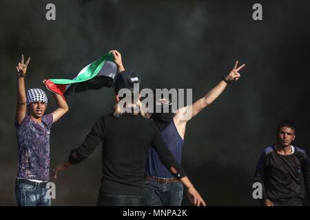 In Gaza. 18 Mai, 2018. Palästinensische Demonstranten Konfrontation mit israelischen Soldaten im Osten Gazastreifen in der Nähe der Grenze mit Israel am 18. Mai 2018. Dutzende palästinensische Demonstranten erschossen und Freitag durch die israelische Armee, Schießereien verletzt und Gas während der Auseinandersetzungen, die Ärzte sagten. Credit: Wissam Nassar/Xinhua/Alamy leben Nachrichten Stockfoto