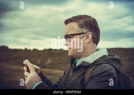 Ein Tourist, der Bilder von Hadleigh Park (Essex, UK) mit seinem Smartphone Stockfoto