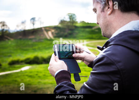 Ein Tourist, der Bilder von Hadleigh Park (Essex, UK) mit seinem Smartphone Stockfoto