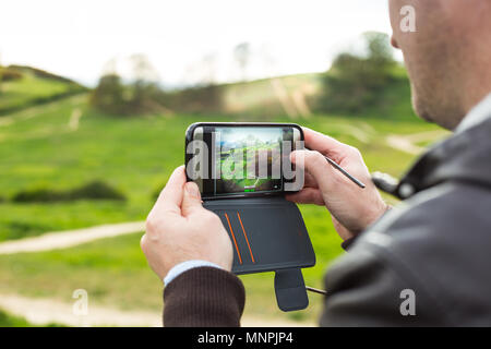 Ein Tourist, der Bilder von Hadleigh Park (Essex, UK) mit seinem Smartphone Stockfoto