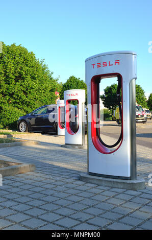 Ellwangen, Deutschland - 10. Mai 2018: Tesla Kompressor Stationen (480-Volt-DC-schnell-Ladestationen) und Tesla Auto im Hintergrund. Stockfoto