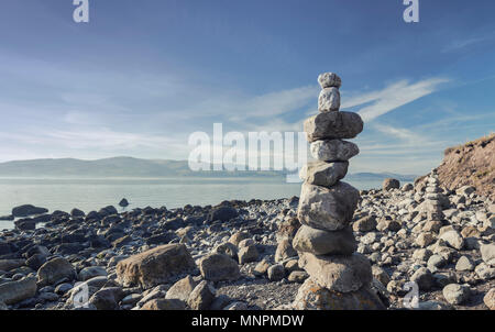 Stapel von Felsen auf Menai Strait mit spektakulärem Blick auf die Berge von Snowdonia. Insel Anglesey im Norden von Wales. Großbritannien Stockfoto