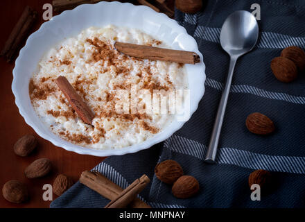 Nahaufnahme der weiße Schüssel mit cremiger Milchreis mit Zimt auf Stoff serviert geerdet Stockfoto