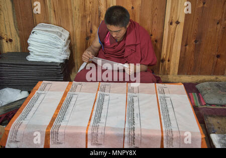 Mönch, handgeschöpftem Papier Schrift und Holzschnitte in der heiligen Schrift Bakong Druckmaschine Kloster in Dege, Sichuan, China Stockfoto