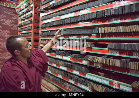 Reihen von handgemachten Holzschnitt Buddhistische Schrift druckt in der heiligen Schrift Bakong Druckmaschine Kloster in Dege, Sichuan, China eingereicht Stockfoto