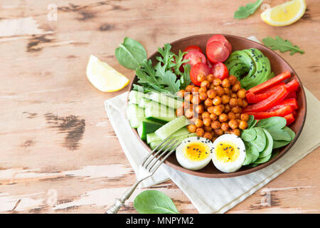 Buddha Schüssel, gesunde und ausgewogene Ernährung. Frittierte Kichererbsen, Tomaten, Gurken, Paprika, Eier, Spinat, Rucola. Stockfoto