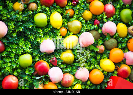 Eine Zusammenstellung von Obst auf einem weißen Hintergrund. Muster aus frischen Früchten. Ansicht von oben, flache Bauform. Collage von Pflaume, Trauben, Äpfel, Blumen, Nektar Stockfoto