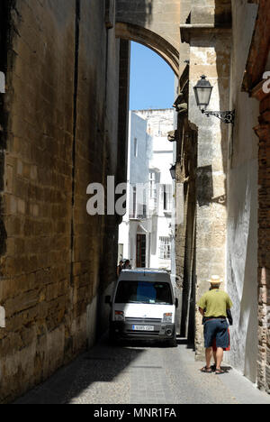 Ein van drückt durch eine Lücke in einer engen Gasse, zwei Meter breit Hoch über angrenzende sind Bögen der maurischen Architektur in einer kleinen mittelalterlichen Stadt ein Stockfoto