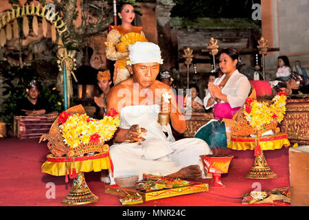 BALI - Januar 19: Legong Trance & Paradies Tanz in Ubud Palace. Vor der Leistung, Priester religiöse Zeremonie von Angeboten und segne alle akt Stockfoto