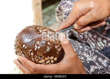 Handwerk - Mann carving Coconut auf traditionelle Weise, Bali, Indonesien Stockfoto