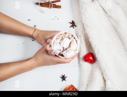 Hände, die heiße Schokolade Tasse mit Marshmallow. Stockfoto