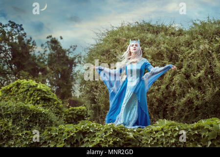 Frau elf zaubert in einem Märchenwald, sie ist in einem antiken Kleid angezogen. Stockfoto