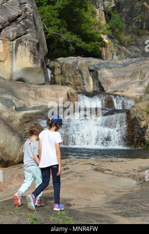 Zwei junge Mädchen in der Badenden Wanderungen auf einem Pfad durch einen Wald, Jourama Falls, Bruce Hwy, Yuruga QLD, Australia Stockfoto