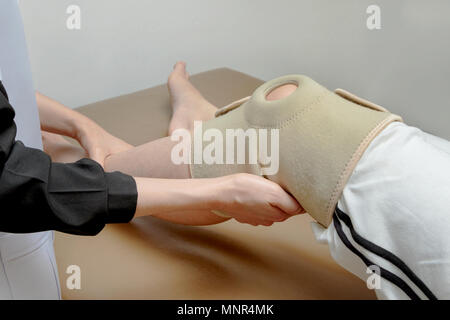 Physiotherapeuten Anwendung knie Unterstützung der Patient Knie, Rehabilitation Stockfoto