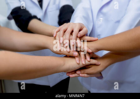 Ärzte und Krankenschwestern in einem medizinischen Team stapeln Hände, medizinische Zusammenarbeit im Team Stockfoto
