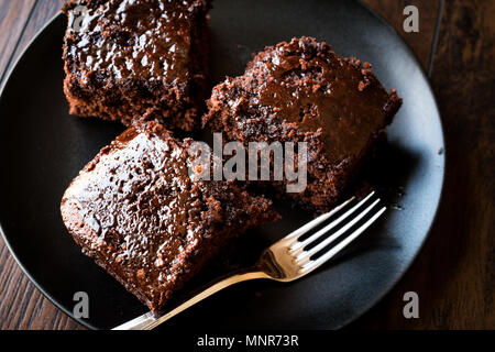 Feuchte Schokolade Biskuit Brownie Stücke in schwarze Platte. Organische Wüste. Stockfoto