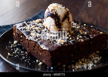Chocolate Brownie mit Eis und Haselnuss Pulver. Dessert Konzept. Stockfoto