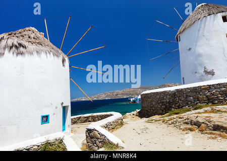 Weiß griechischen Windmühlen mit Blick auf Klein Venedig beliebtes Reiseziel am traditionellen Dorf auf der Insel Mykonos, Griechenland, Europa Stockfoto