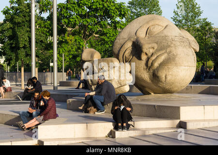 Menschen sitzen in der Nähe der Skulptur Ecoute (hören) von Henri de Miller in Paris, Frankreich. Stockfoto