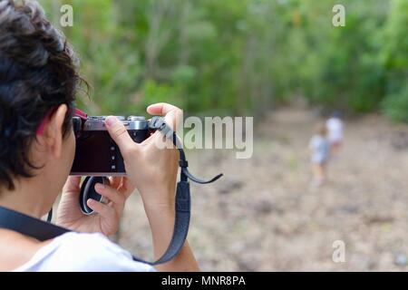 Mutter nimmt Bilder von ihren Töchtern gehen durch einen Wald, Paluma Range National Park, Rollingstone QLD, Australia Stockfoto