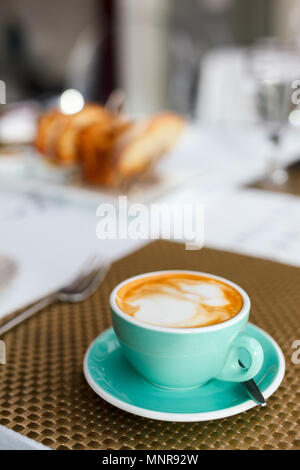 Frischer Kaffee in türkis Schale serviert zum Frühstück Stockfoto